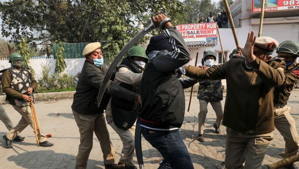 A man wields his sword against a policeman during a clash between protesting farmers and a group of people shouting anti-farmer slogans, at a site of the protest against farm laws at Singhu border near New Delhi, India January 29, 2021. A man wields his sword against a policeman during a clash between protesting farmers and a group of people shouting anti-farmer slogans, at a site of the protest against farm laws at Singhu border near New Delhi, India January 29, 2021. - Sputnik International