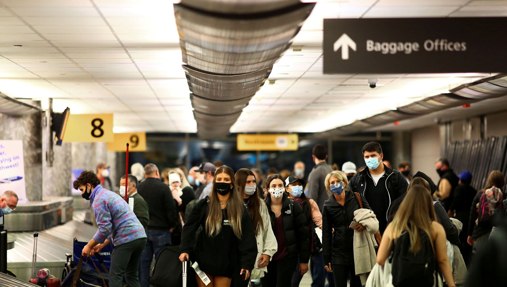 Travelers wearing protective face masks to prevent the spread of the coronavirus disease (COVID-19) reclaim their luggage at the airport in Denver, Colorado, U.S., November 24, 2020. Travelers wearing protective face masks to prevent the spread of the coronavirus disease (COVID-19) reclaim their luggage at the airport in Denver, Colorado, U.S., November 24, 2020. - Sputnik International, 1920, 20.02.2021
