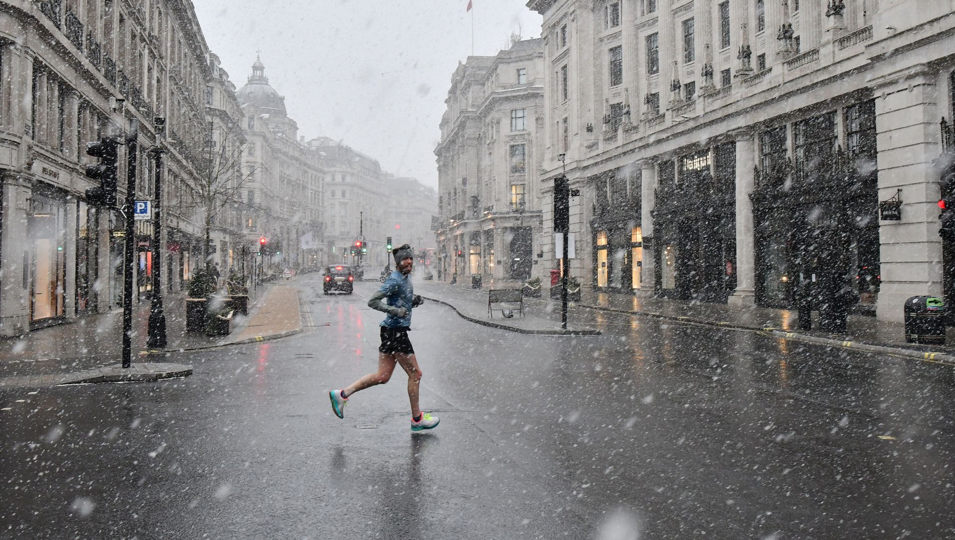 A jogger taking his daily exercise, crosses Regent Street in London in the snow on January 24, 2021, as the capital experiences a rare covering of snow on Sunday. A jogger taking his daily exercise, crosses Regent Street in London in the snow on January 24, 2021, as the capital experiences a rare covering of snow on Sunday. - Sputnik International, 1920, 01.02.2021