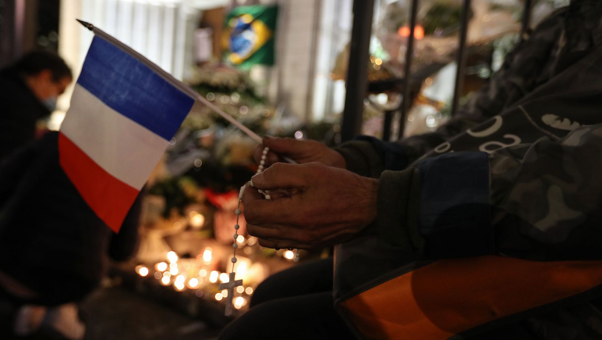 A person holds a French national flag and a rosary outside Notre-Dame de l'Assomption Basilica in Nice on October 31, 2020, to pay tribute to the victims two days after a knife attacker killed three people, cutting the throat of two, inside the church of the French Riviera city, and police arrest a young Tunisian migrant from Sfax who arrived in Europe only last month, according to French prosecutors. A person holds a French national flag and a rosary outside Notre-Dame de l'Assomption Basilica in Nice on October 31, 2020, to pay tribute to the victims two days after a knife attacker killed three people, cutting the throat of two, inside the church of the French Riviera city, and police arrest a young Tunisian migrant from Sfax who arrived in Europe only last month, according to French prosecutors. - Sputnik International, 1920, 02.02.2021