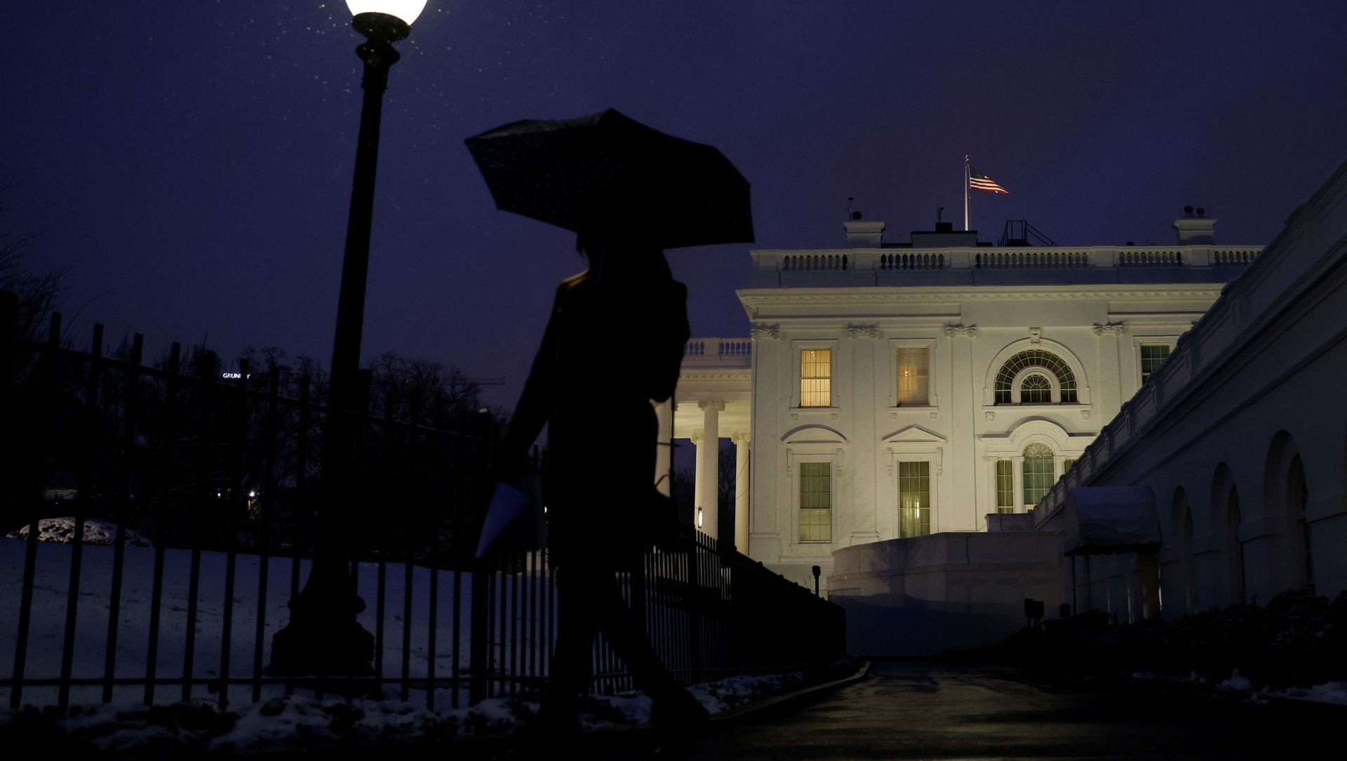 A staff member walks while holding an umbrella under snowfall at the White House in Washington, U.S., February 1, 2021. - Sputnik International, 1920, 16.02.2021