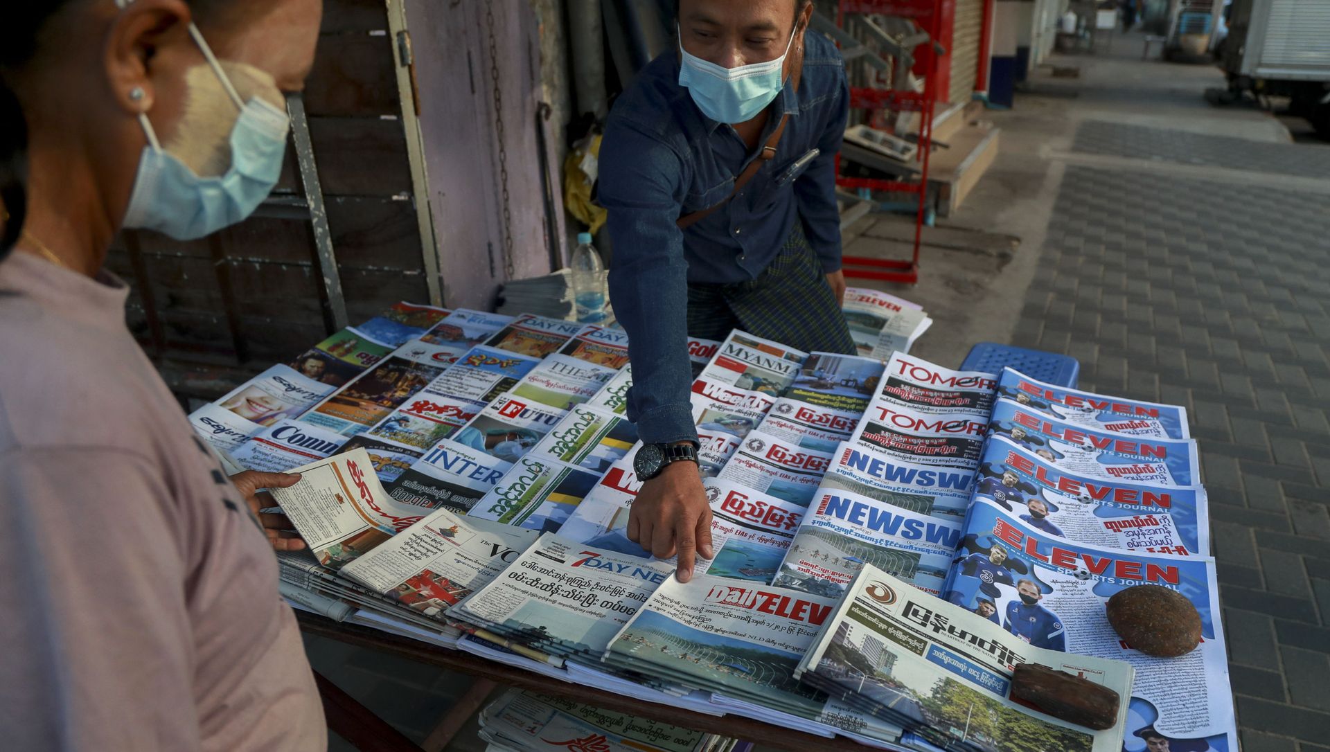 A newspaper seller points at a front-page of a newspaper in Yangon, Myanmar, Tuesday, Feb. 2, 2021. Hundreds of members of Myanmar's Parliament remained confined inside their government housing in the country's capital on Tuesday, a day after the military staged a coup and detained senior politicians including Nobel laureate and de facto leader Aung San Suu Kyi. A newspaper seller points at a front-page of a newspaper in Yangon, Myanmar, Tuesday, Feb. 2, 2021. Hundreds of members of Myanmar's Parliament remained confined inside their government housing in the country's capital on Tuesday, a day after the military staged a coup and detained senior politicians including Nobel laureate and de facto leader Aung San Suu Kyi. - Sputnik International, 1920, 02.02.2021