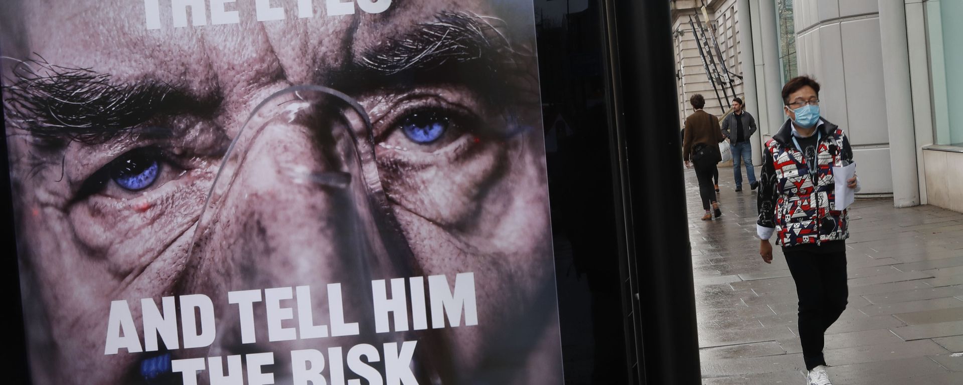 A man wearing a mask against coronavirus walks past an NHS advertisement about COVID-19 in London, Tuesday, Feb. 2, 2021. - Sputnik International, 1920, 26.07.2022