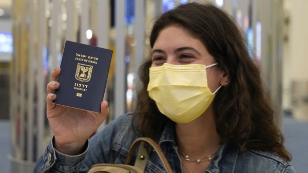 In this 26 November 2020 file photo, an Israeli passenger from a flyDubai flight from Tel Aviv, Israel, waves her Israeli passport on arrival at Dubai International Airport's Terminal 3 in Dubai, United Arab Emirates.  - Sputnik International