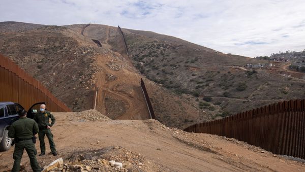 U.S. border patrol agents stand near the location of halted construction along the U.S. Border wall with Mexico as an unfinished  section is shown on Otay Mountain, east of San Diego, California, U.S., February 2, 2021. - Sputnik International