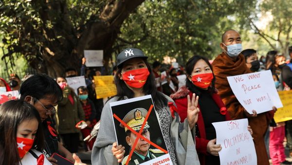 A woman holds a poster of Myanmar's army chief Min Aung Hlaing with his face crossed out during a protest, organised by Chin Refugee Committee, against the military coup in Myanmar, in New Delhi, India, February 5, 2021. REUTERS/Anushree Fadnavis - Sputnik International