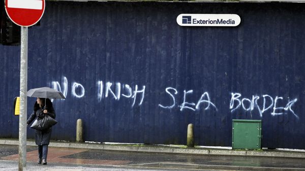 A woman walks past past graffiti with the words 'No Irish Sea Border' in Belfast city centre, Northern Ireland, Wednesday, Feb. 3, 2021 - Sputnik International