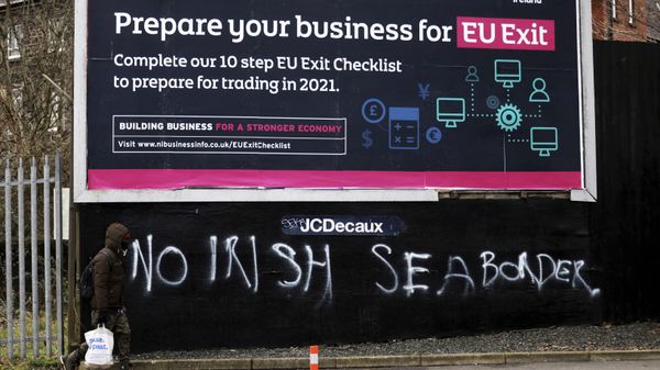 A man walks past graffiti reading No Irish sea border in the mainly loyalist Donegal road area of South Belfast, Northern Ireland, Saturday, Jan. 30, 2021 - Sputnik International