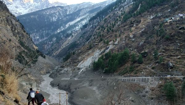 People walk past a destroyed dam after a Himalayan glacier broke and crashed into the dam at Raini Chak Lata village in Chamoli district, northern state of Uttarakhand, India, February 7, 2021. - Sputnik International