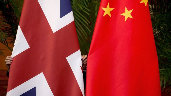 A worker adjusts British and China (R) national flags on display for a signing ceremony at the seventh UK-China Economic and Financial Dialogue Roundtable on Public-Private Partnerships at Diaoyutai State Guesthouse in Beijing, China September 21, 2015 - Sputnik International