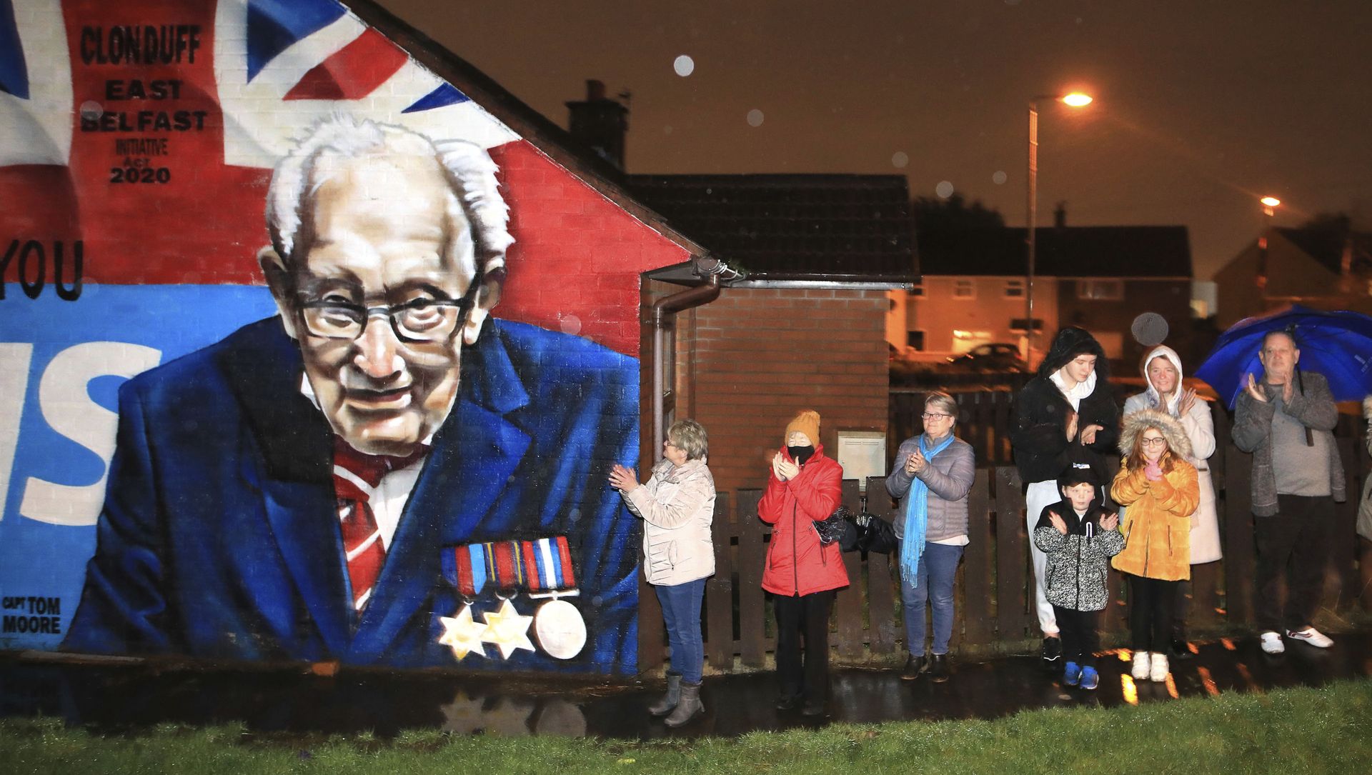 Local residents join a national clap beside a mural of Captain Sir Tom Moore in East Belfast, Northern Ireland, Wednesday, Feb. 3, 2021. Captain Moore passed away Tuesday after being treated with Covid-19 and was known for his achievements raising millions of pounds for the NHS charity during the Covid-19 pandemic. Local residents join a national clap beside a mural of Captain Sir Tom Moore in East Belfast, Northern Ireland, Wednesday, Feb. 3, 2021. Captain Moore passed away Tuesday after being treated with Covid-19 and was known for his achievements raising millions of pounds for the NHS charity during the Covid-19 pandemic. - Sputnik International, 1920, 08.02.2021