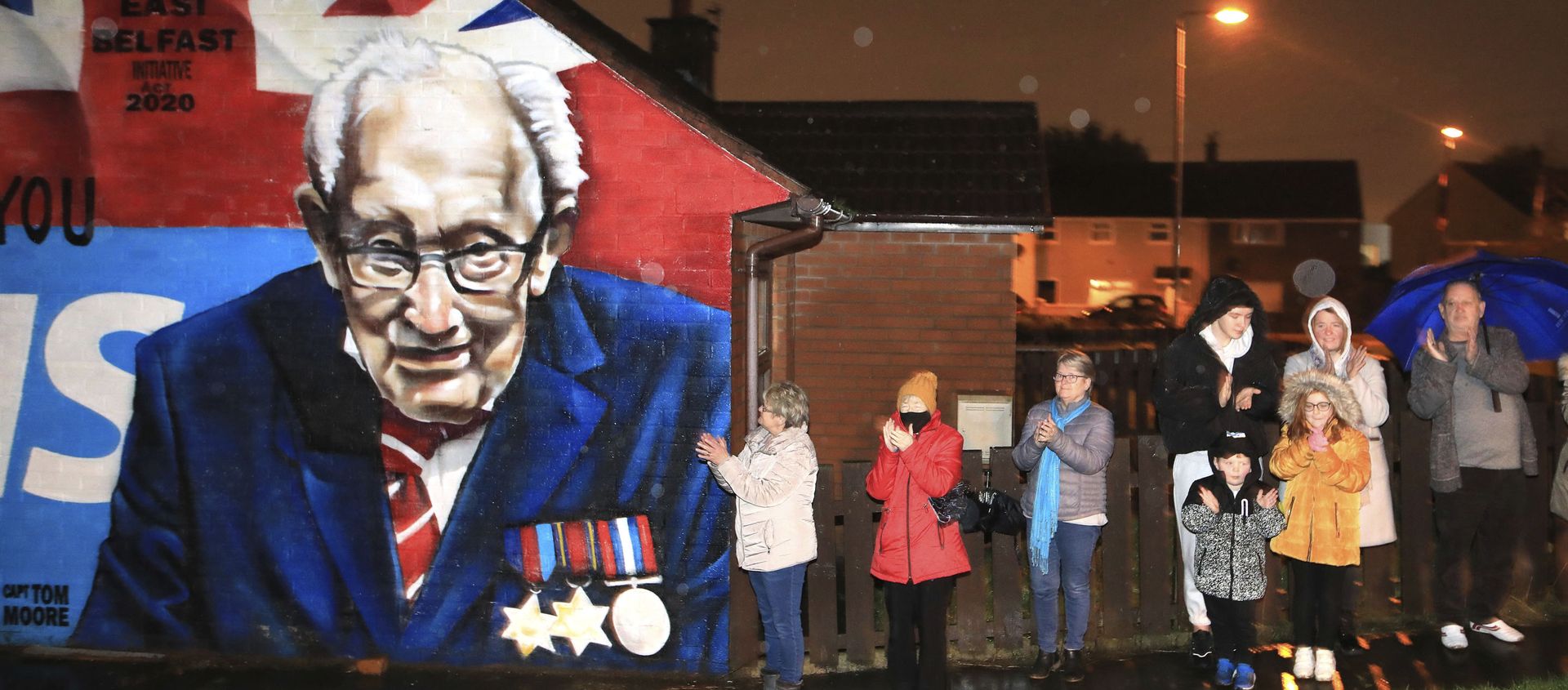 Local residents join a national clap beside a mural of Captain Sir Tom Moore in East Belfast, Northern Ireland, Wednesday, Feb. 3, 2021. Captain Moore passed away Tuesday after being treated with Covid-19 and was known for his achievements raising millions of pounds for the NHS charity during the Covid-19 pandemic. Local residents join a national clap beside a mural of Captain Sir Tom Moore in East Belfast, Northern Ireland, Wednesday, Feb. 3, 2021. Captain Moore passed away Tuesday after being treated with Covid-19 and was known for his achievements raising millions of pounds for the NHS charity during the Covid-19 pandemic. - Sputnik International, 1920, 08.02.2021