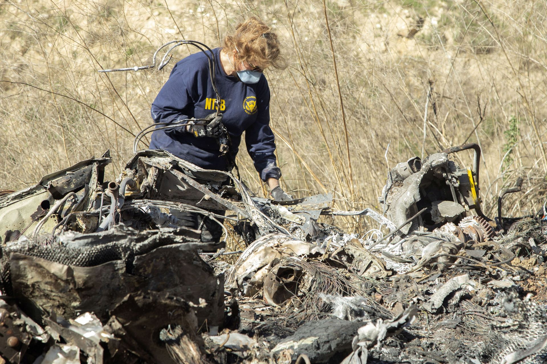 FILE - In this Jan. 27, 2020, file photo, released by the National Transportation Safety Board, NTSB investigator Carol Hogan examines wreckage as part of the NTSB's investigation of a helicopter crash near Calabasas, Calif., that killed former NBA basketball player Kobe Bryant, his 13-year-old daughter, Gianna, and seven others. Federal safety investigators bypassed aviation regulators on Tuesday, June 2, 2020, and urged leading helicopter manufacturers to install so-called black boxes that would help determine the cause of crashes such as the one that killed former NBA star Kobe Bryant. FILE - In this Jan. 27, 2020, file photo, released by the National Transportation Safety Board, NTSB investigator Carol Hogan examines wreckage as part of the NTSB's investigation of a helicopter crash near Calabasas, Calif., that killed former NBA basketball player Kobe Bryant, his 13-year-old daughter, Gianna, and seven others. Federal safety investigators bypassed aviation regulators on Tuesday, June 2, 2020, and urged leading helicopter manufacturers to install so-called black boxes that would help determine the cause of crashes such as the one that killed former NBA star Kobe Bryant. - Sputnik International, 1920, 25.08.2022