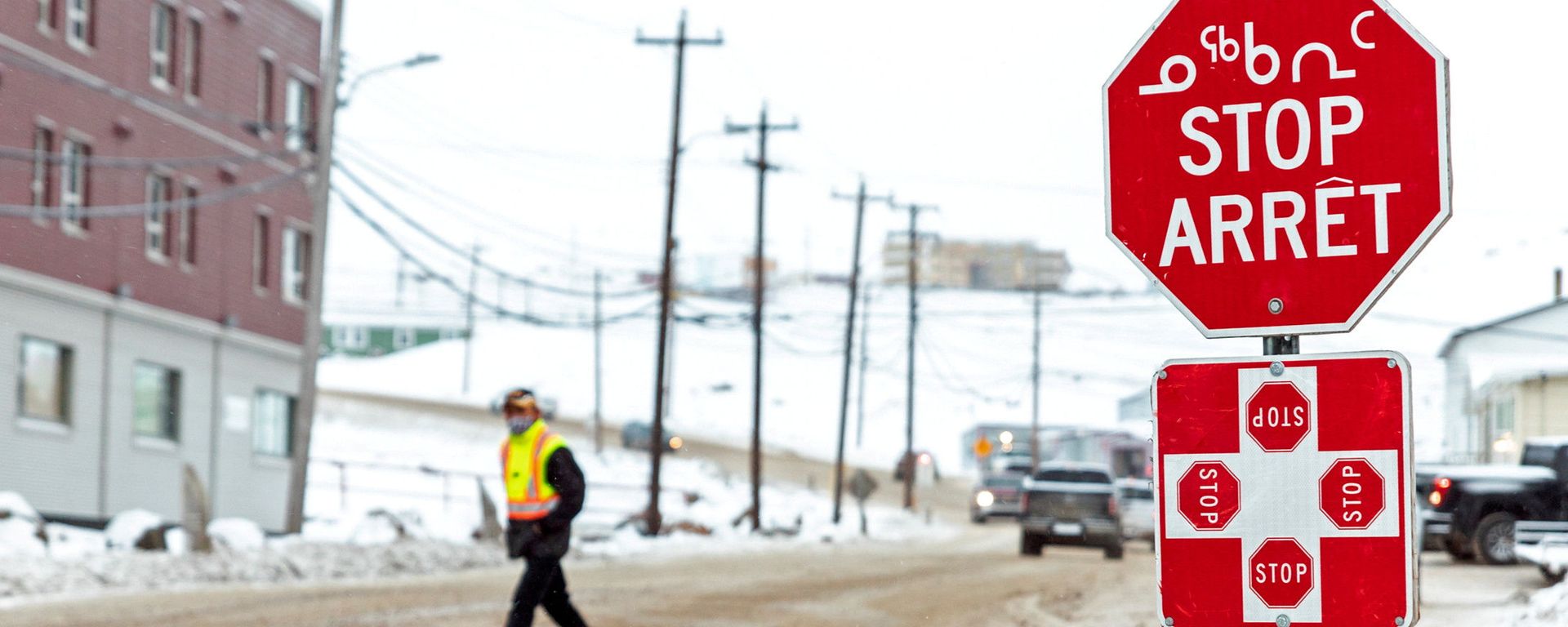 A man wearing a mask to help slow the spread of coronavirus disease (COVID-19) passes a stop sign written in English, French and Inuktitut as the territory of Nunavut enters a two week mandatory restriction period in Iqaluit, Nunavut, Canada 18 November 2020. - Sputnik International, 1920, 02.03.2021