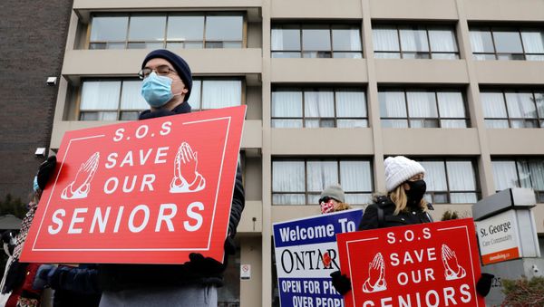 A man wearing a mask to help slow the spread of coronavirus disease (COVID-19) passes a stop sign written in English, French and Inuktitut as the territory of Nunavut enters a two week mandatory restriction period in Iqaluit, Nunavut, Canada, 18 November 2020. - Sputnik International