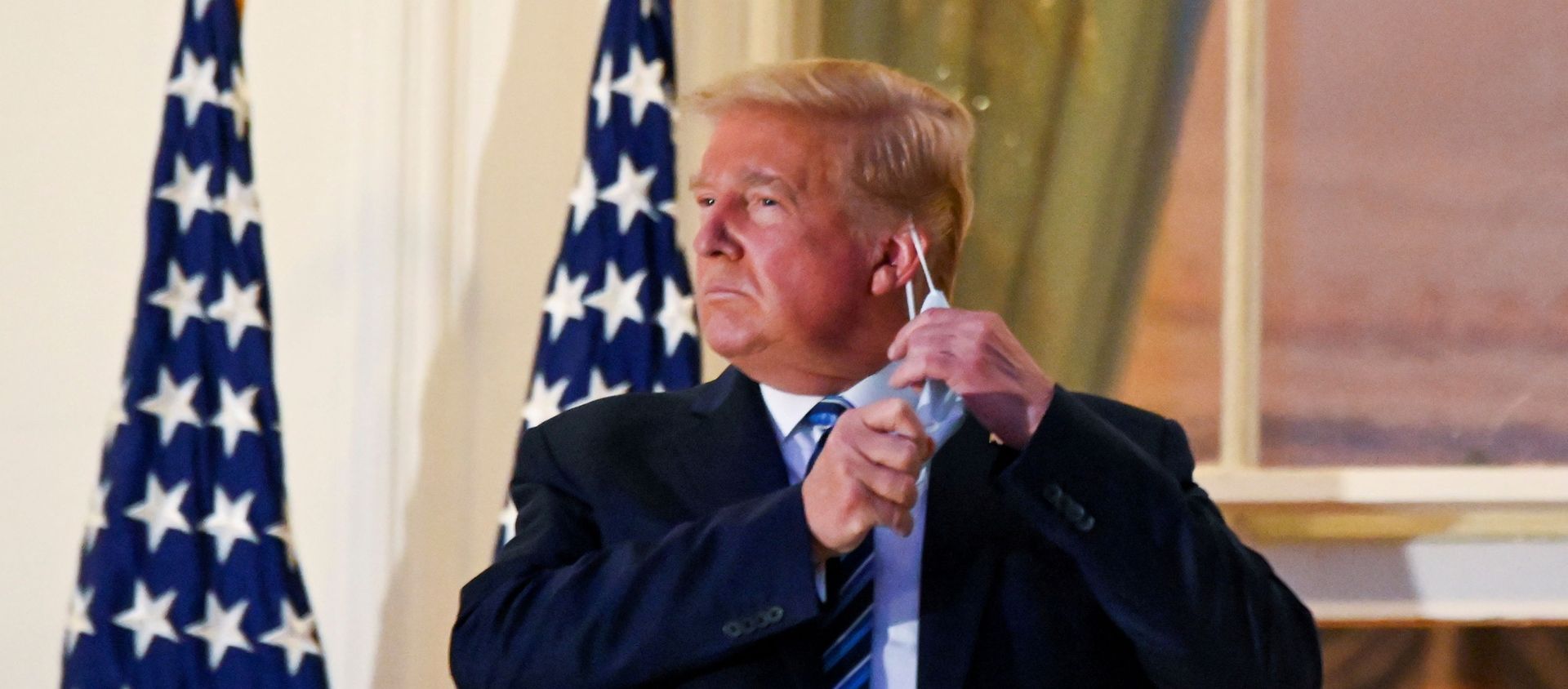 U.S. President Donald Trump pulls off his protective face mask as he poses atop the Truman Balcony of the White House after returning from being hospitalized at Walter Reed Medical Center for coronavirus disease (COVID-19) treatment, in Washington, U.S. October 5, 2020 - Sputnik International, 1920, 22.02.2021