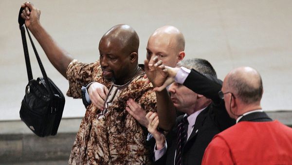 Protestor Toyin Agbetu, left, is stopped by security staff after he interrupted a service to mark the bicentenary of the 1807 act to abolish the slave trade, attended by Britain's Queen Elizabeth II, unseen, at London's Westminster Abbey, Tuesday March 27, 2007.  - Sputnik International