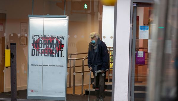  man wearing a face mask looks from a window of an HSBC bank as Britain began its third COVID-19 lockdown in Fulham, London, Britain, January 5, 2021.   - Sputnik International