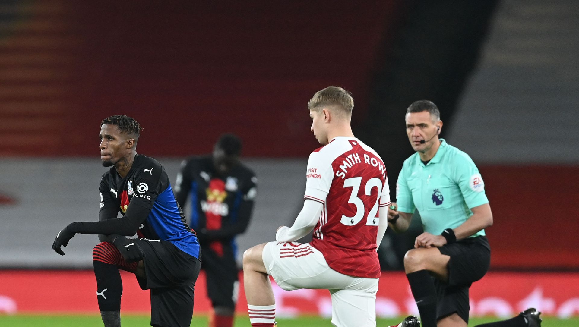 Crystal Palace's Ivorian striker Wilfried Zaha (L), Arsenal's English midfielder Emile Smith Rowe (2nd R) and English referee Andre Marriner (R) 'take the knee' in support of the No Room For Racism campaign. Crystal Palace's Ivorian striker Wilfried Zaha (L), Arsenal's English midfielder Emile Smith Rowe (2nd R) and English referee Andre Marriner (R) 'take the knee' in support of the No Room For Racism campaign. - Sputnik International, 1920, 13.02.2021