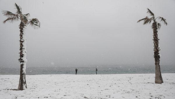 People take photos on a snow-covered beach during heavy snowfall in the suburb of Glyfada, in Athens, Greece, February 16, 2021. - Sputnik International
