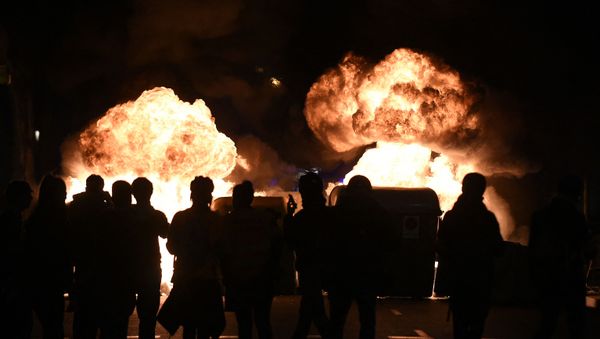 Flames rise from burning trash containers during clashes between protesters and Catalan regional police forces Mossos d'Esquadra after a demonstration against the arrest of Spanish rapper Pablo Hasel in Barcelona on February 16, 2021. - Sputnik International