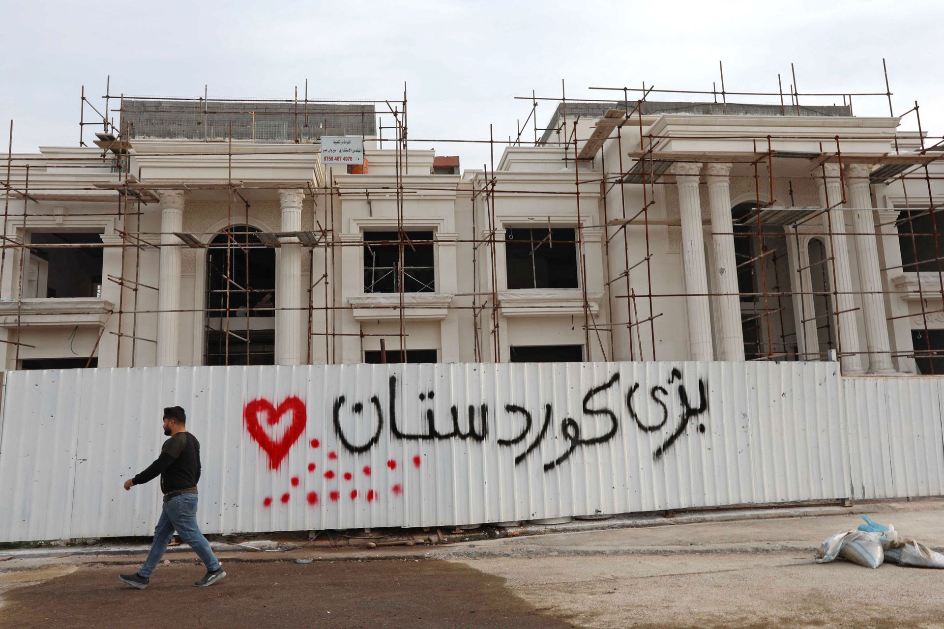 A man walks past a graffiti reading in Kurdish Long live Kurdistan”, near the scene of a rocket attack in Arbil, the capital of the northern Iraqi Kurdish autonomous region, on February 16, 2021. - Sputnik International, 1920, 11.09.2021