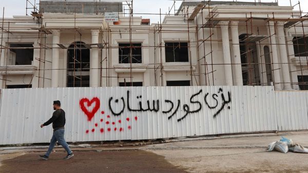 A man walks past a graffiti reading in Kurdish Long live Kurdistan”, near the scene of a rocket attack in Arbil, the capital of the northern Iraqi Kurdish autonomous region, on February 16, 2021. - Sputnik International