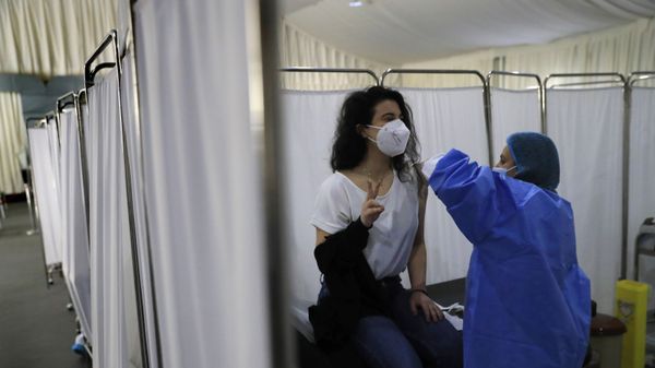 A woman flashes a victory sign as she receives the Pfizer-BioNTech COVID-19 vaccine during a nationwide vaccination campaign, at the Saint George Hospital, in Beirut, Lebanon, Tuesday, Feb. 16, 2021. - Sputnik International