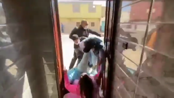 Plainclothes Moroccan security forces drag Elwaara Khaya, sister of Saharawi human rights activist Sultana Khaya, from their home in Bojador, Western Sahara, on February 13, 2021. - Sputnik International