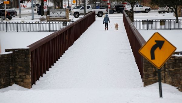 Anna Thomasson walks her dog, Penny, across the White Rock Lake Spillway after winter weather caused electricity blackouts in Dallas - Sputnik International