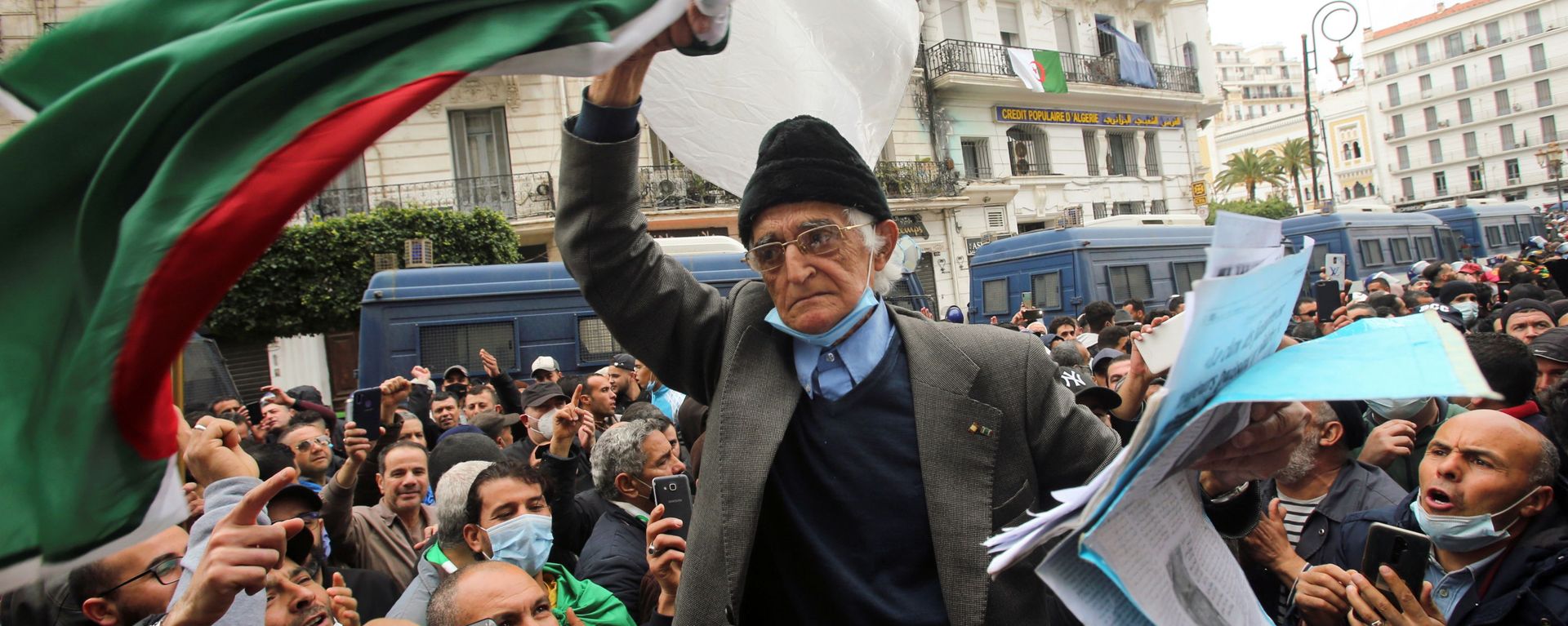 A demonstrator carries a national flag during a protest to mark the second anniversary of a mass protest movement demanding political change, in Algiers, Algeria February 22, 2021 A demonstrator carries a national flag during a protest to mark the second anniversary of a mass protest movement demanding political change, in Algiers, Algeria February 22, 2021 - Sputnik International, 1920, 23.09.2021