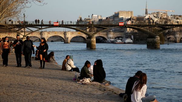 People enjoy a sunny and warm weather sitting on the banks of the River Seine in Paris amid the coronavirus disease (COVID-19) outbreak in France on 24 February 2021.  - Sputnik International
