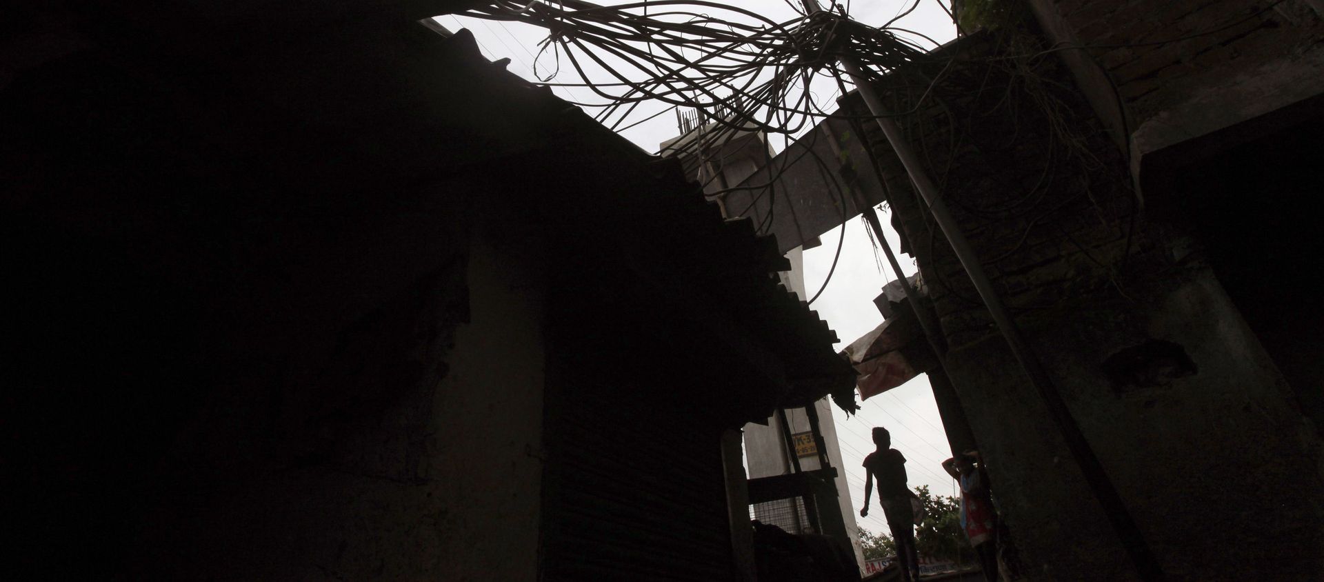 An Indian girl walks a narrow lane beneath a power pole with high-voltage cables coiling around at a slum in Mumbai, India, Friday, Aug. 3, 2012 An Indian girl walks a narrow lane beneath a power pole with high-voltage cables coiling around at a slum in Mumbai, India, Friday, Aug. 3, 2012 - Sputnik International, 1920, 01.03.2021
