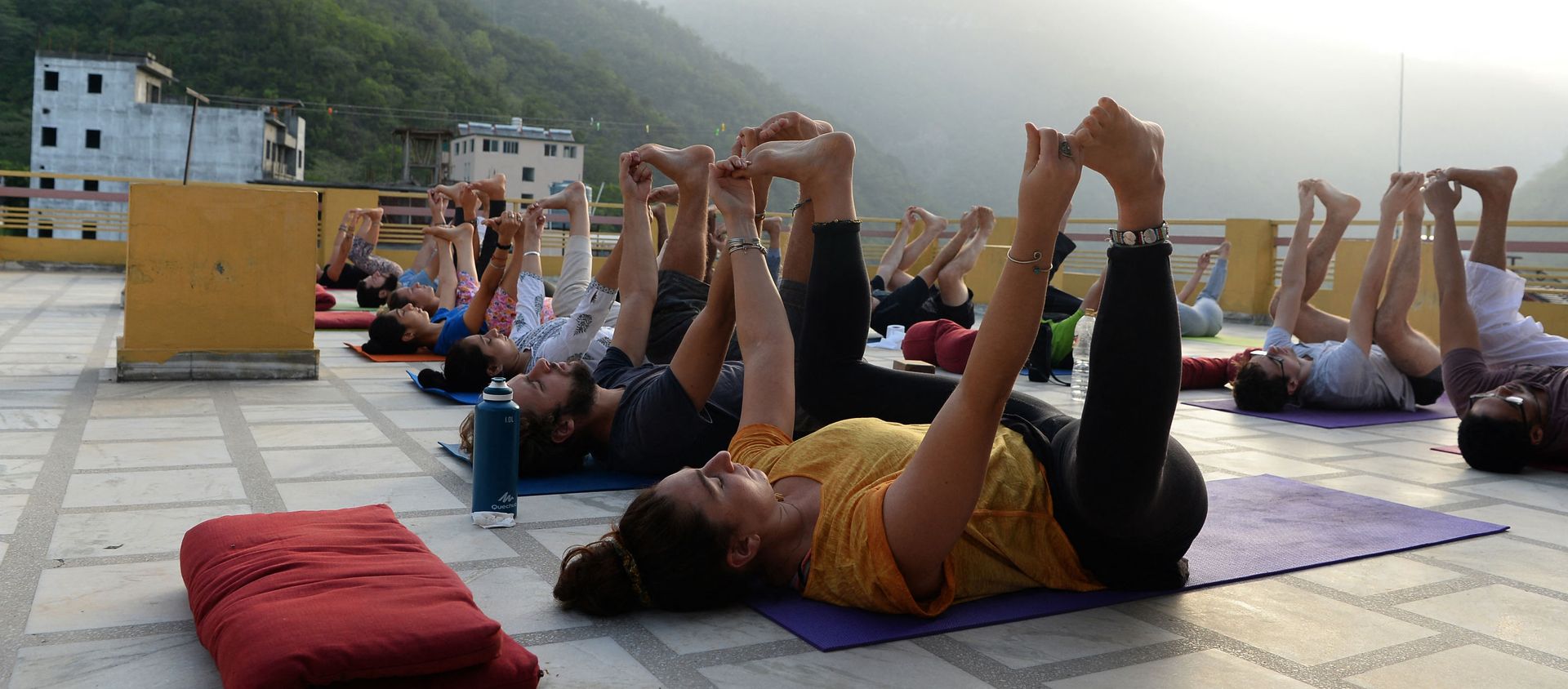 This picture taken on June 19, 2018, shows people practising yoga on a terrace at the Anand Prakash yoga ashram in Rishikesh in India's Uttarakhand state This picture taken on June 19, 2018, shows people practising yoga on a terrace at the Anand Prakash yoga ashram in Rishikesh in India's Uttarakhand state - Sputnik International, 1920, 01.03.2021