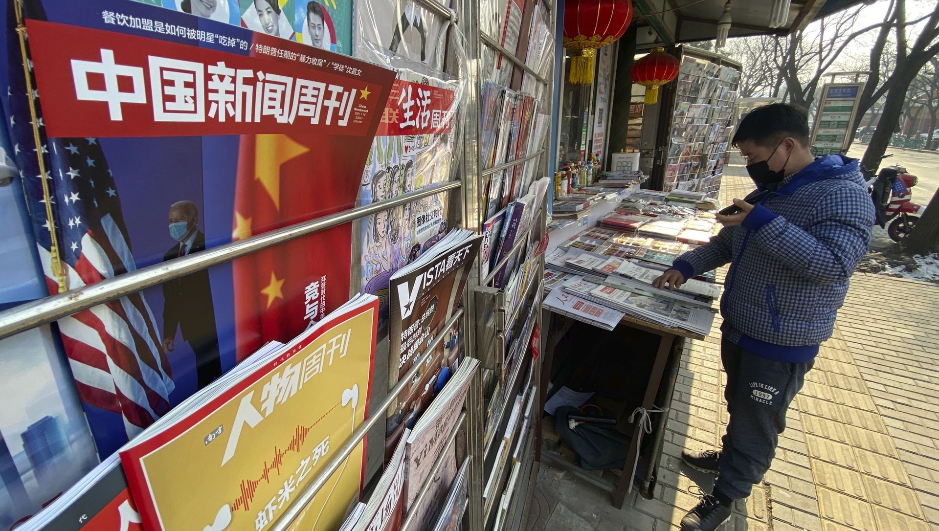 A newsstand vendor looks through his display near a magazine with a cover depicting U.S. President Joe Biden near U.S. and Chinese flags in Beijing on Thursday, Jan. 21, 2021 A newsstand vendor looks through his display near a magazine with a cover depicting U.S. President Joe Biden near U.S. and Chinese flags in Beijing on Thursday, Jan. 21, 2021 - Sputnik International, 1920, 02.03.2021