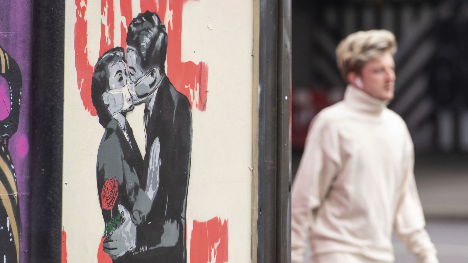 A man passes a poster showing a couple wearing protective face masks embracing in Shoreditch area of east London, following the introduction of measures to bring England out of the coronavirus lockdown, Thursday June 4, 2020 - Sputnik International, 1920, 29.11.2021
