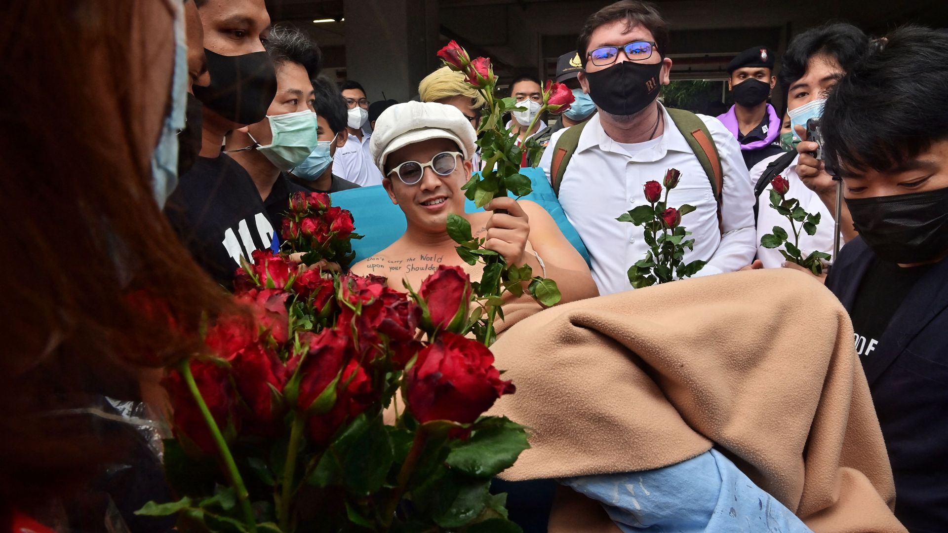 Anti-government blues musician Ammy The Bottom Blues receives flowers as he is wheeled on a hospital bed outside the Office of the Attorney General in Bangkok on February 17, 2021, before the state prosecutor decided whether to indict 18 activists on charges including sedition and lese majeste related to anti-government protests in 2020. - Sputnik International, 1920, 03.03.2021