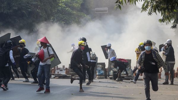 Anti-coup protesters run from teargas and charging riot police and soldiers in Mandalay, Myanmar, Wednesday, March 3, 2021 - Sputnik International
