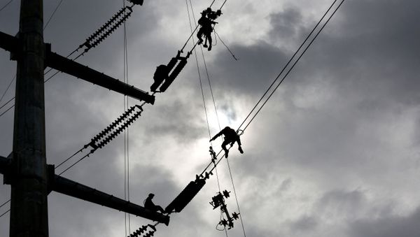 Technicians work on an electricity transmission tower on the outskirts of Yangon on July 8, 2020 - Sputnik International