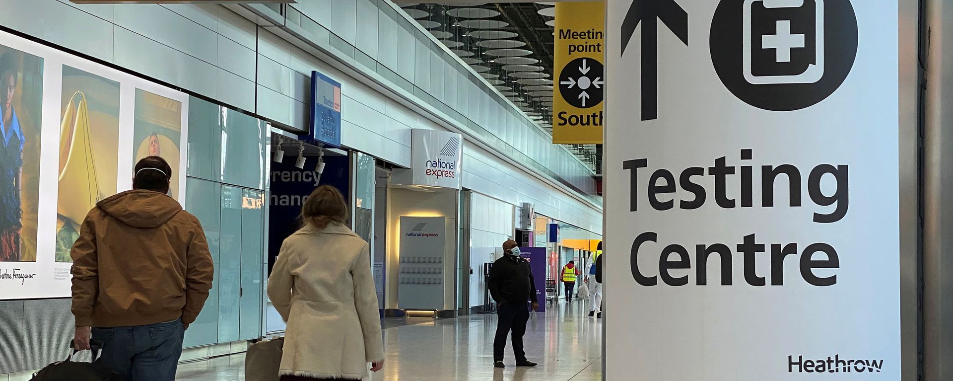 Travellers pass a sign for a COVID-19 test centre at Heathrow Airport, London, Britain, February 13, 2021. - Sputnik International, 1920, 26.07.2021
