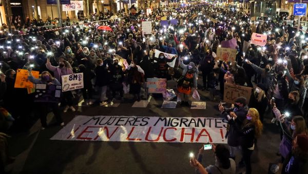 People gather to mark International Women's Day, amid the coronavirus disease (COVID-19) pandemic, in Barcelona, Spain March 8, 2021. The banner reads  Migrant women fighting!   - Sputnik International