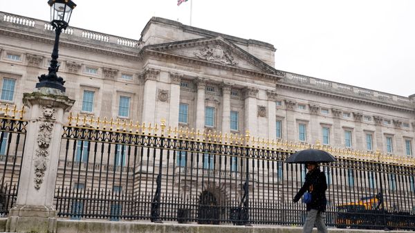 A woman holding an umbrella walks past Buckingham Palace as the snow falls. - Sputnik International