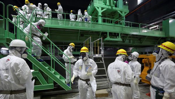 FILE PHOTO: Members of the media and Tokyo Electric Power Co. (TEPCO) employees wearing protective suits and masks walk down the steps of a fuel-handling machine at the spent fuel pool inside the No.4 reactor building at the tsunami-crippled TEPCO's Fukushima Daiichi nuclear power plant in Fukushima prefecture November 7, 2013.  - Sputnik International