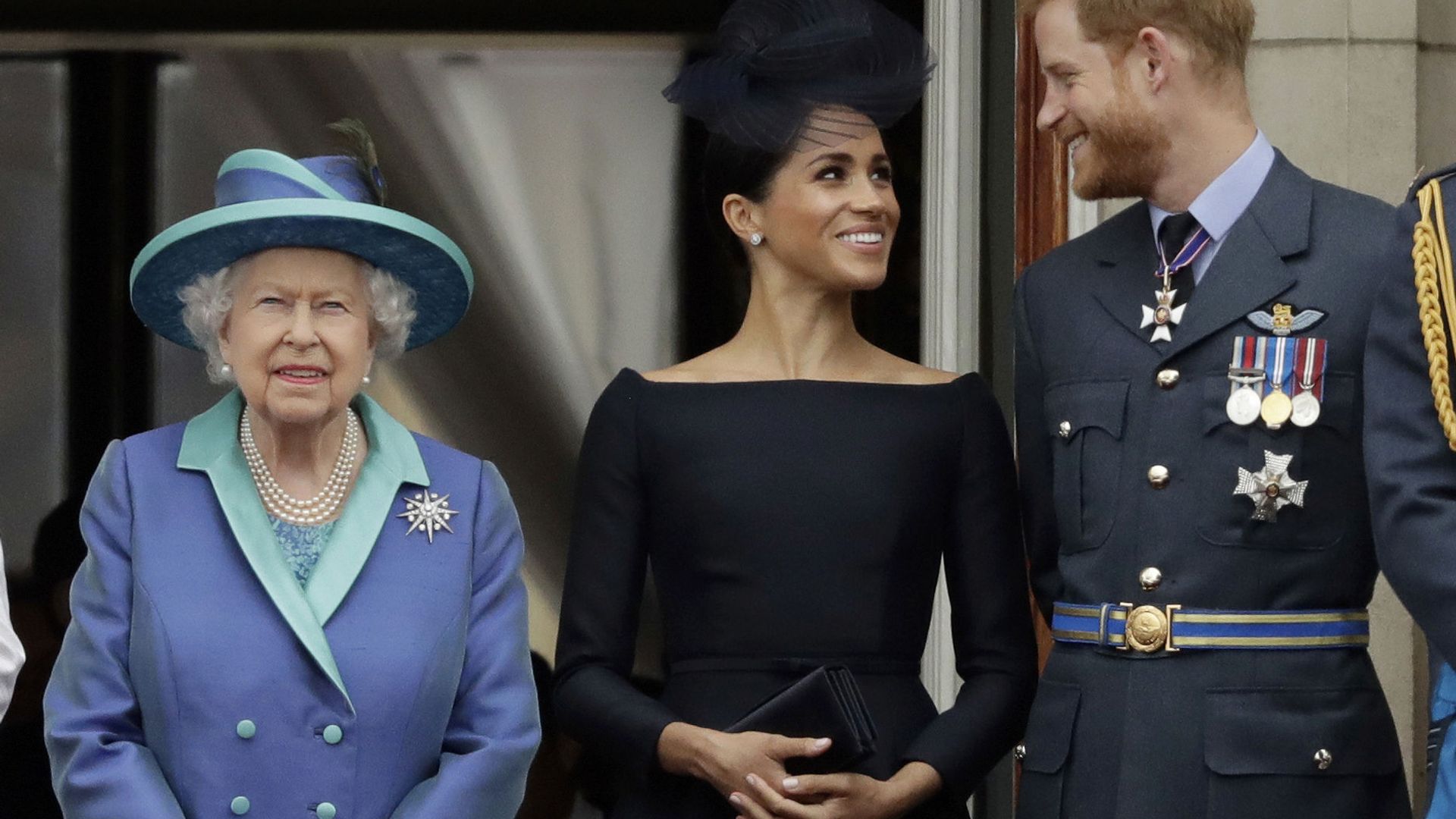 In this Tuesday, July 10, 2018 file photo Britain's Queen Elizabeth II, and Meghan the Duchess of Sussex and Prince Harry watch a flypast of Royal Air Force aircraft pass over Buckingham Palace in London In this Tuesday, July 10, 2018 file photo Britain's Queen Elizabeth II, and Meghan the Duchess of Sussex and Prince Harry watch a flypast of Royal Air Force aircraft pass over Buckingham Palace in London - Sputnik International, 1920, 17.03.2021
