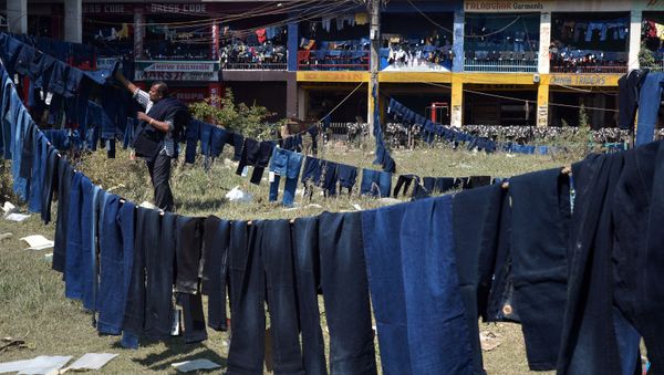 A Kashimri worker of a ready-made garment shop hangs flood-damaged stock to dry in a park outside the shop in Srinagar on September 18, 2014 - Sputnik International