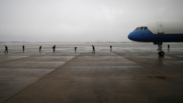 Air Force One crew members scan the tarmac following a previous day ice storm, ahead of U.S. President Joe Biden's trip to Michigan, at Joint Base Andrews in Maryland, U.S., February 19, 2021.  - Sputnik International
