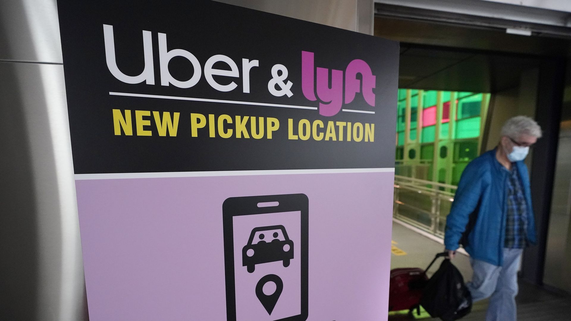 A passer-by pulls luggage while walking past a sign offering directions to an Uber and Lyft ride pickup location at Logan International Airport, in Boston, Tuesday, Feb. 9, 2021. Businesses like Uber, Airbnb and Square were born in recessions. Now, the effects of COVID-19 are forcing existing businesses to reinvent themselves, and some of today's most significant business obstacles will spark new startups offering innovative solutions. (AP Photo/Steven Senne) A passer-by pulls luggage while walking past a sign offering directions to an Uber and Lyft ride pickup location at Logan International Airport, in Boston, Tuesday, Feb. 9, 2021. Businesses like Uber, Airbnb and Square were born in recessions. Now, the effects of COVID-19 are forcing existing businesses to reinvent themselves, and some of today's most significant business obstacles will spark new startups offering innovative solutions. (AP Photo/Steven Senne) - Sputnik International, 1920, 18.03.2022
