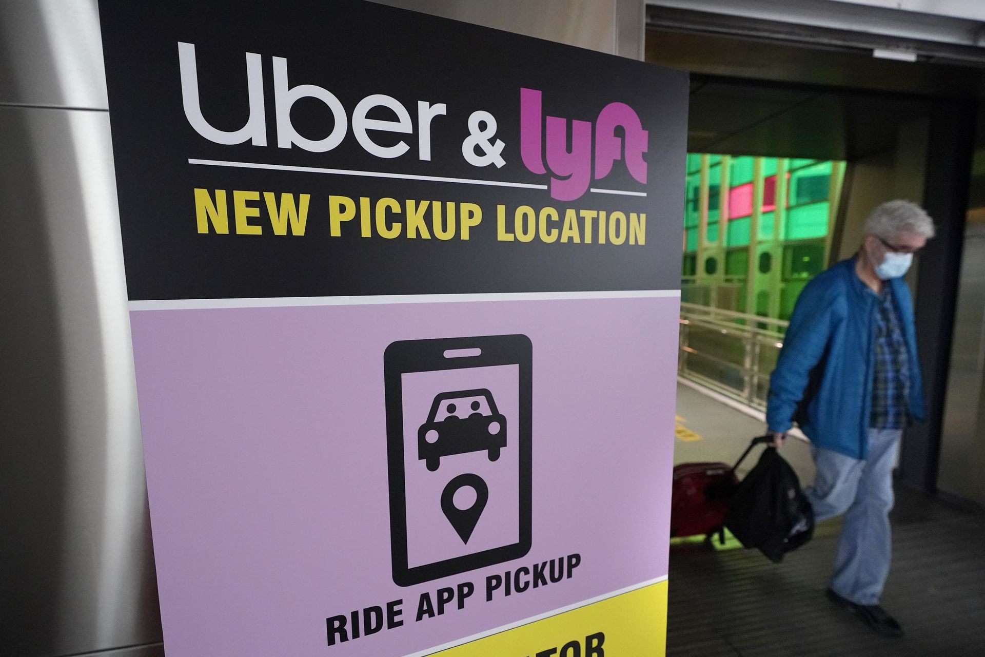 A passer-by pulls luggage while walking past a sign offering directions to an Uber and Lyft ride pickup location at Logan International Airport, in Boston, Tuesday, Feb. 9, 2021. Businesses like Uber, Airbnb and Square were born in recessions. Now, the effects of COVID-19 are forcing existing businesses to reinvent themselves, and some of today's most significant business obstacles will spark new startups offering innovative solutions. (AP Photo/Steven Senne) A passer-by pulls luggage while walking past a sign offering directions to an Uber and Lyft ride pickup location at Logan International Airport, in Boston, Tuesday, Feb. 9, 2021. Businesses like Uber, Airbnb and Square were born in recessions. Now, the effects of COVID-19 are forcing existing businesses to reinvent themselves, and some of today's most significant business obstacles will spark new startups offering innovative solutions. (AP Photo/Steven Senne) - Sputnik International, 1920, 07.09.2021