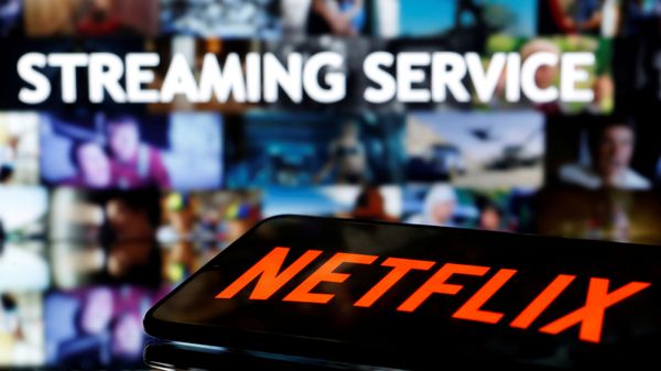 FILE PHOTO: A smartphone with the Netflix logo lies in front of displayed Streaming service words in this illustration taken March 24, 2020 - Sputnik International