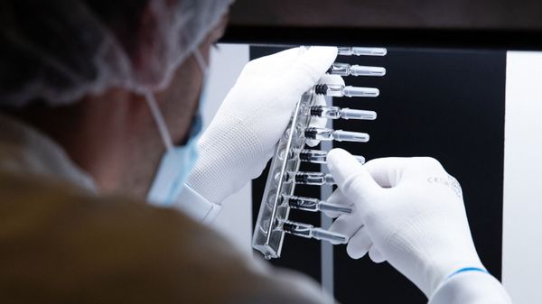 A laboratory technician inspects defunct syringes which were set aside by an automatic inspection machine at a French pharmaceutical company Sanofi's world distribution centre in Val de Reuil on July 10, 2020 - Sputnik International